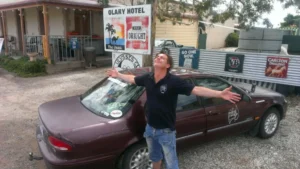Paul Moore on location filming Random Aussies, embracing the outback spirit outside the Olary Hotel during an Australian road trip series about human connection and storytelling.