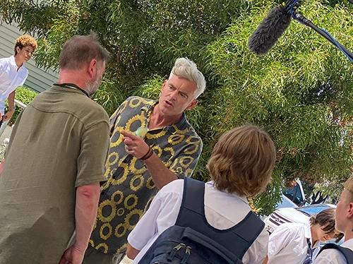 Paul Moore directing a scene outdoors on Stashamo High, discussing shots with the crew and young performers in Geelong.
