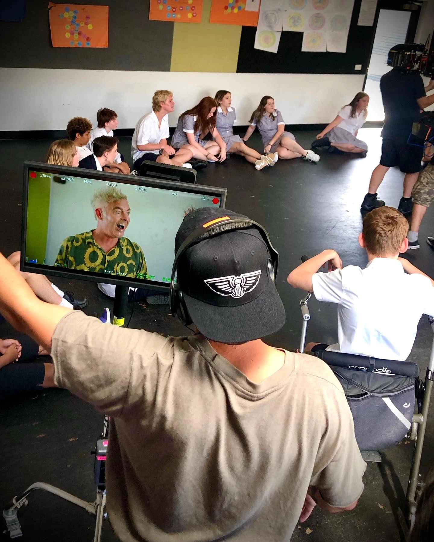 Paul Moore directing a classroom scene in Stashamo High, captured behind the camera working with young actors.