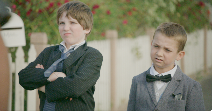 Two confident young students from Stashamo High strut across campus in suits, showing up their teachers in this playful Geelong film moment.