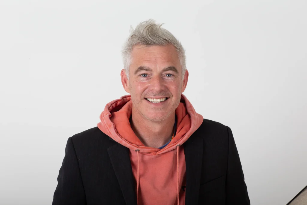 Paul Moore smiling in a studio portrait